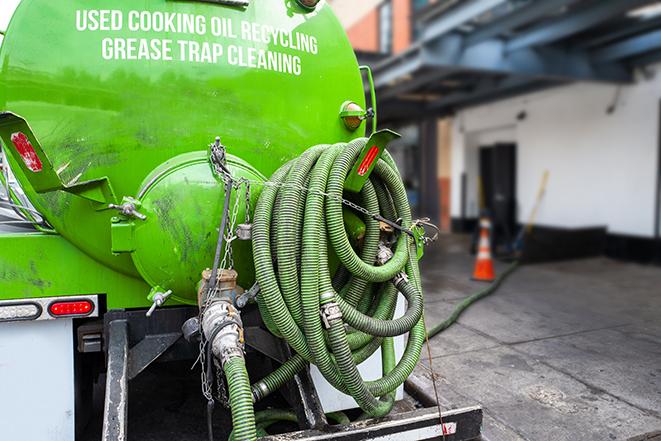 a technician pumping a grease trap in a commercial building in Haddonfield